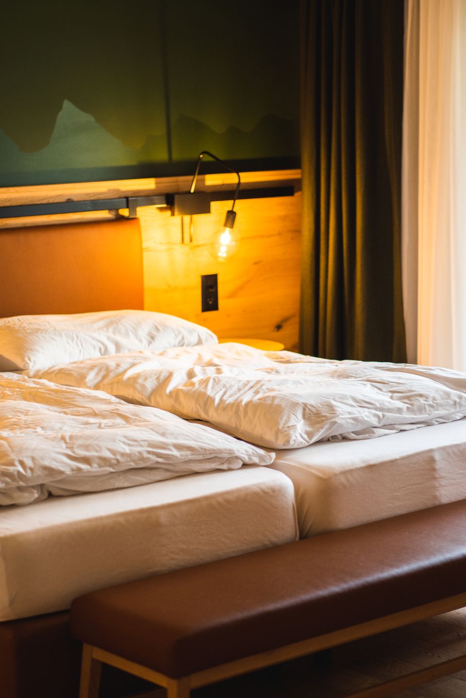 A guest room with a large bed and soft lighting